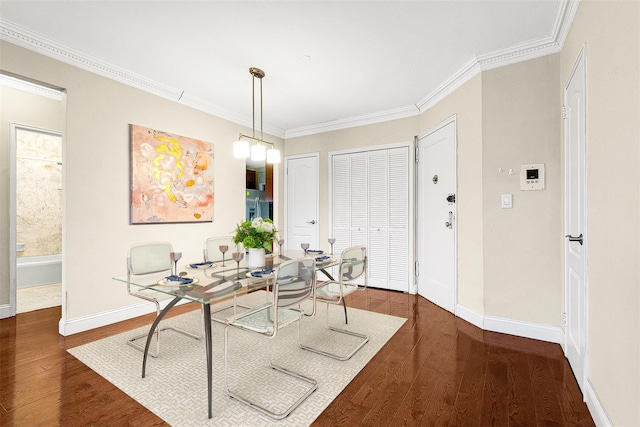 dining area featuring baseboards, wood finished floors, and ornamental molding