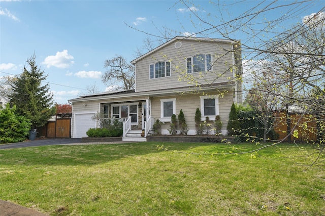 traditional-style house featuring driveway, a front lawn, and a garage
