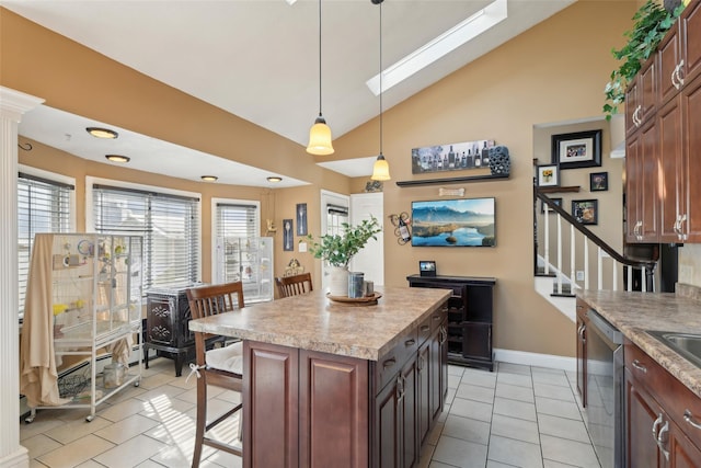 kitchen with a wealth of natural light, light tile patterned floors, stainless steel dishwasher, and vaulted ceiling with skylight