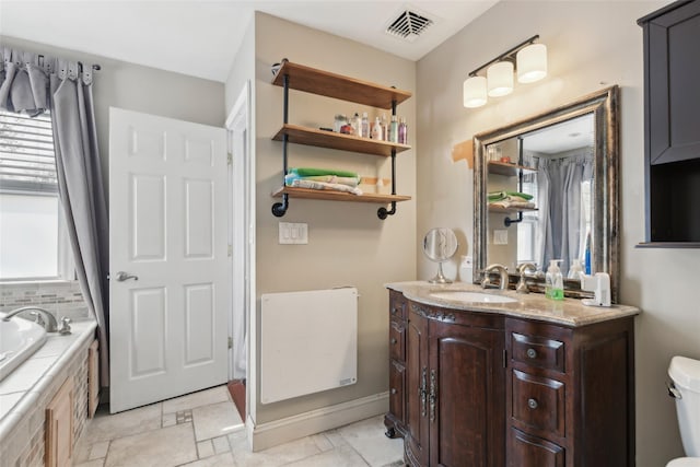 full bathroom featuring a relaxing tiled tub, visible vents, toilet, and vanity