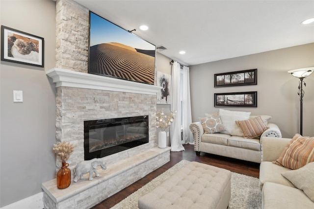 living room featuring dark wood-style floors, visible vents, a fireplace, and recessed lighting