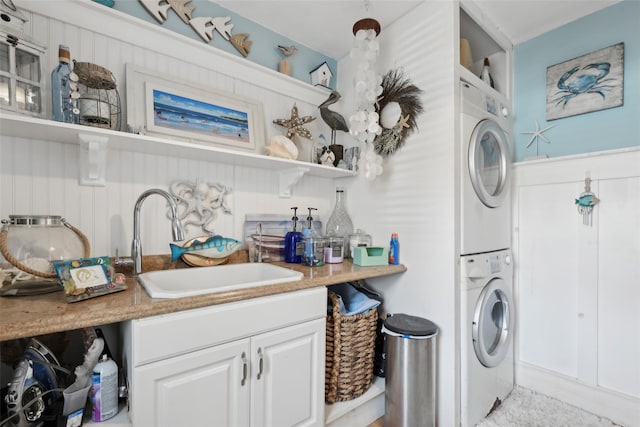 laundry area featuring stacked washer / dryer and a sink
