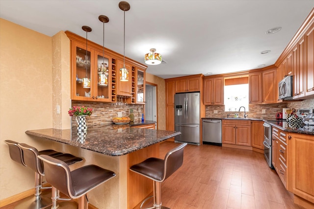 427 Wanamaker St, Oceanside, NY 11572 - kitchen with a kitchen breakfast bar, tasteful backsplash, glass insert cabinets, stainless steel appliances, and a peninsula