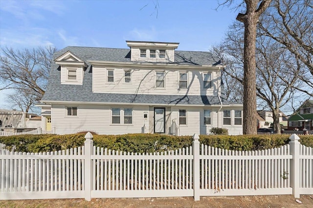 shingle-style home featuring a shingled roof and fence private yard