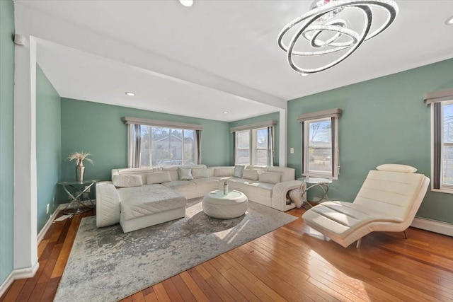 living area featuring baseboards, a notable chandelier, hardwood / wood-style floors, and recessed lighting