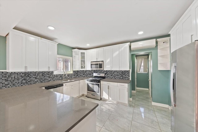 kitchen featuring a wall mounted air conditioner, tasteful backsplash, stainless steel appliances, and plenty of natural light