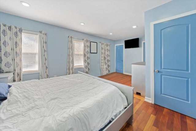 bedroom featuring wood finished floors, recessed lighting, and a closet
