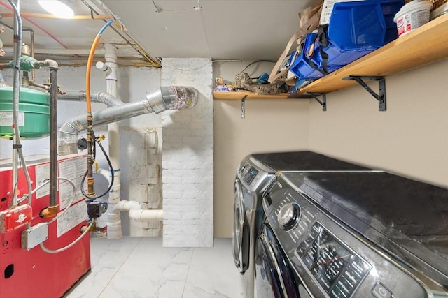 laundry room with washing machine and clothes dryer, marble finish floor, and laundry area
