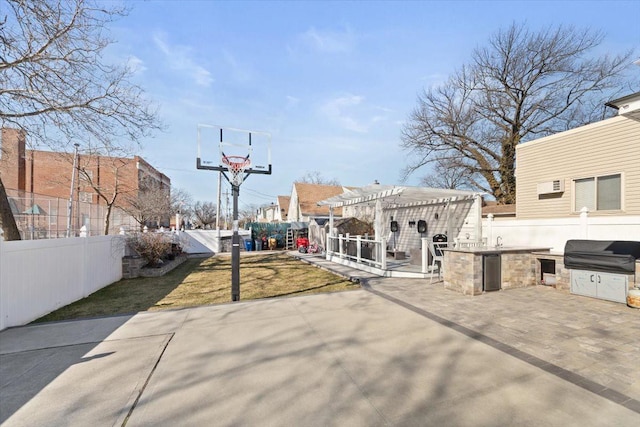 view of sport court with a lawn, a pergola, and a fenced backyard