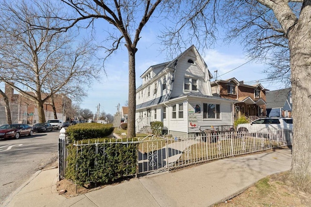 view of front of home featuring a gambrel roof and a fenced front yard