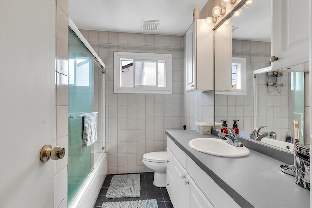 full bathroom with visible vents, tile patterned floors, a wealth of natural light, and tile walls