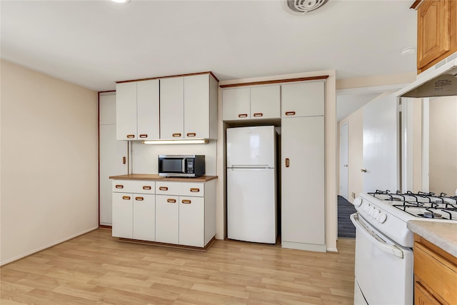 kitchen featuring white appliances, light countertops, light wood-style flooring, baseboards, and under cabinet range hood