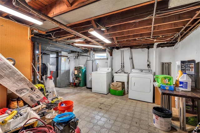below grade area with washer and clothes dryer, a sink, and water heater
