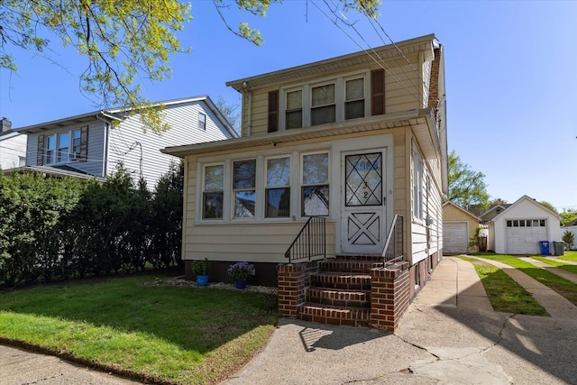 view of front facade with entry steps, a detached garage, an outdoor structure, and a front lawn