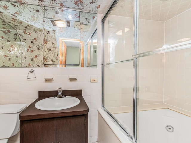 1313 Kearney Ave, Bronx, NY 10465 - full bathroom with wallpapered walls, vanity, tile walls, toilet, and combined bath / shower with glass door
