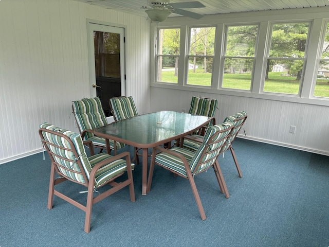 sunroom featuring carpet flooring, a ceiling fan, and a healthy amount of sunlight