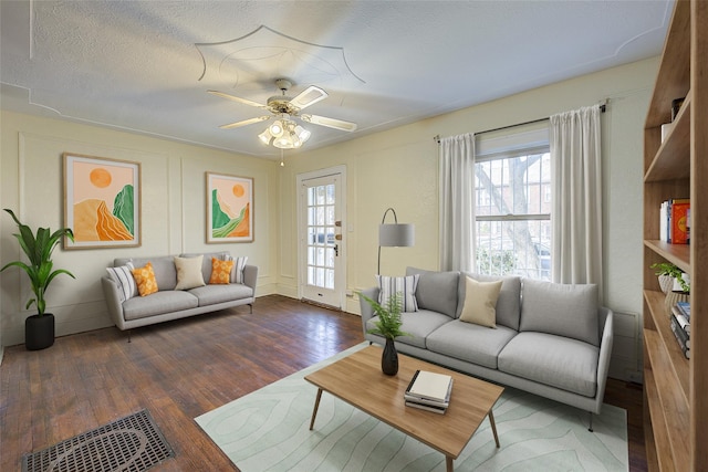 living area featuring visible vents, ceiling fan, wood finished floors, and a wealth of natural light