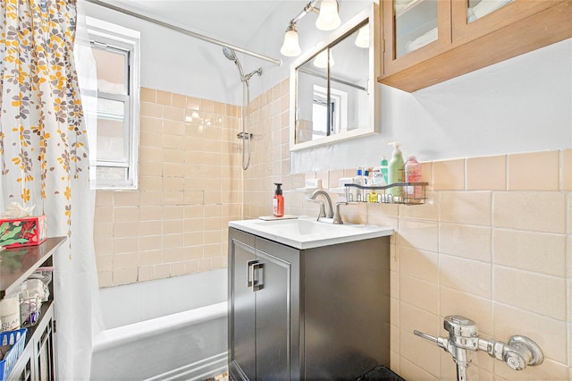 full bathroom featuring tile walls, shower / bathtub combination with curtain, and vanity