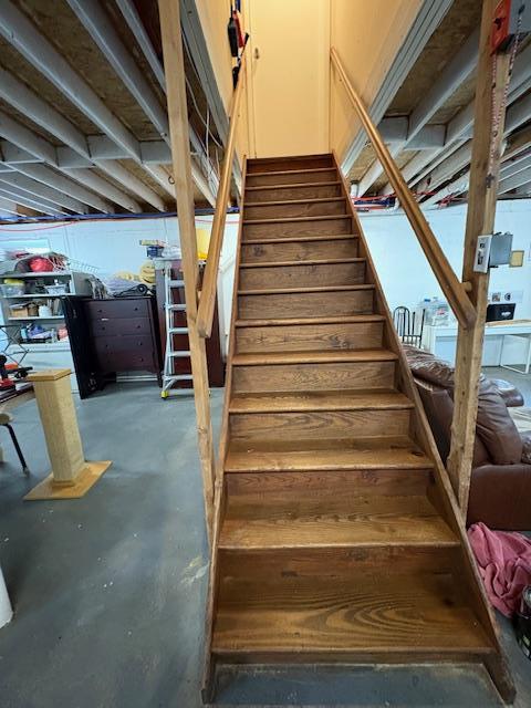 stairs featuring unfinished concrete floors