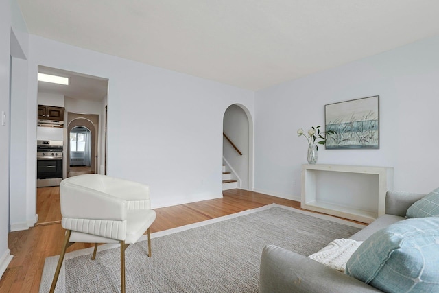 living room featuring stairway and light wood-type flooring