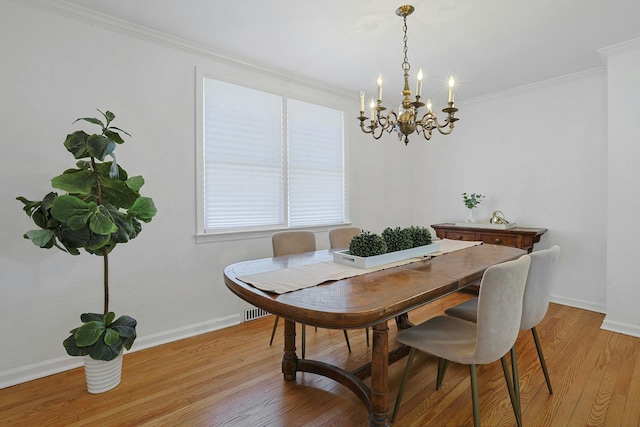 dining area with crown molding, baseboards, a notable chandelier, and light wood-type flooring