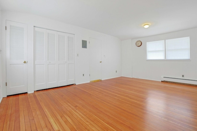 unfurnished bedroom featuring a baseboard radiator and light wood-type flooring