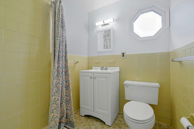 bathroom with tile walls, tile patterned flooring, a wainscoted wall, toilet, and a shower with shower curtain