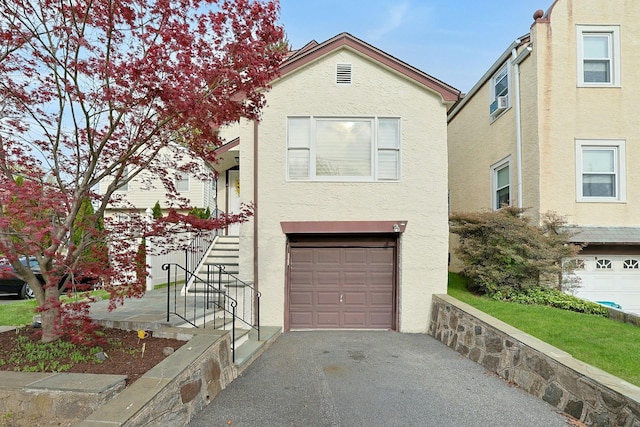 townhome / multi-family property featuring an attached garage, stucco siding, and driveway