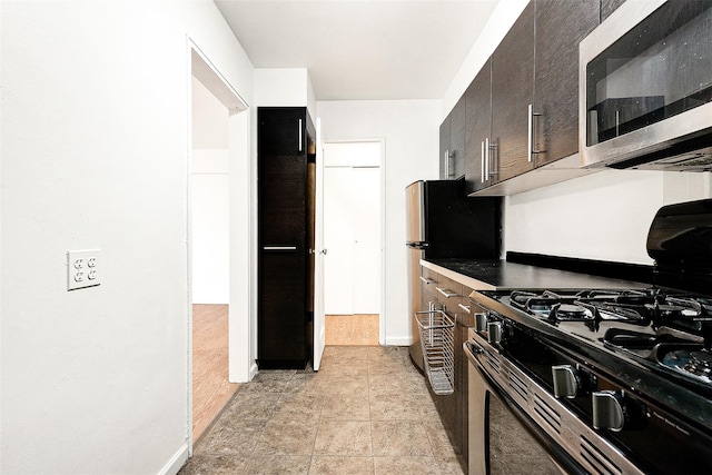 105-15 66th Rd St Unit 4E, Forest Hills, NY 11375 - kitchen with baseboards, stainless steel microwave, dark brown cabinetry, and gas stove