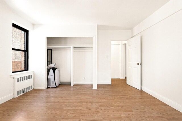 105-15 66th Rd St Unit 4E, Forest Hills, NY 11375 - unfurnished bedroom with baseboards, radiator heating unit, light wood finished floors, and a closet