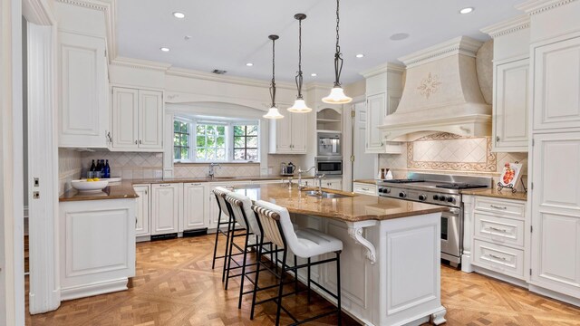 3 Pin Oak Ct, Old Brookville, NY 11545 - kitchen featuring stainless steel appliances, a sink, premium range hood, a kitchen bar, and a center island with sink
