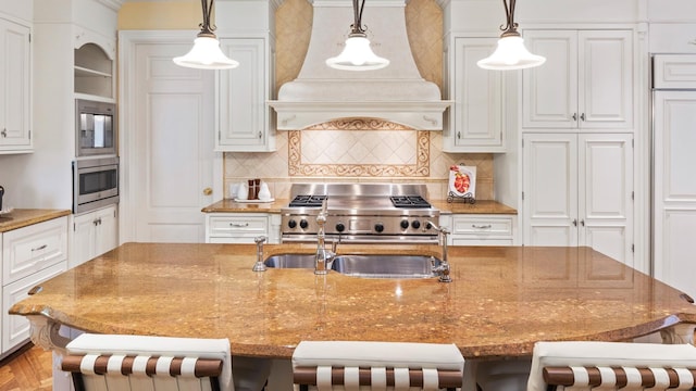 3 Pin Oak Ct, Old Brookville, NY 11545 - kitchen featuring range, custom range hood, a breakfast bar area, backsplash, and a center island with sink