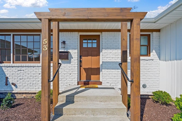 entrance to property featuring brick siding and board and batten siding