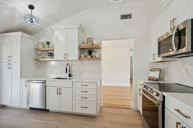 kitchen featuring open shelves, appliances with stainless steel finishes, a sink, visible vents, and lofted ceiling