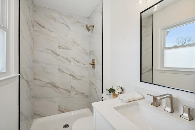 bathroom featuring a marble finish shower, toilet, and vanity