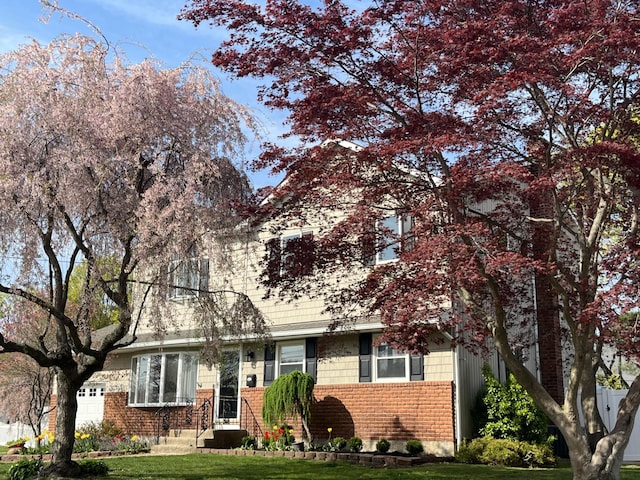 view of front facade with a front lawn and brick siding