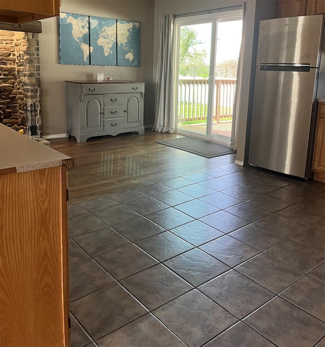 interior space with baseboards and dark tile patterned floors