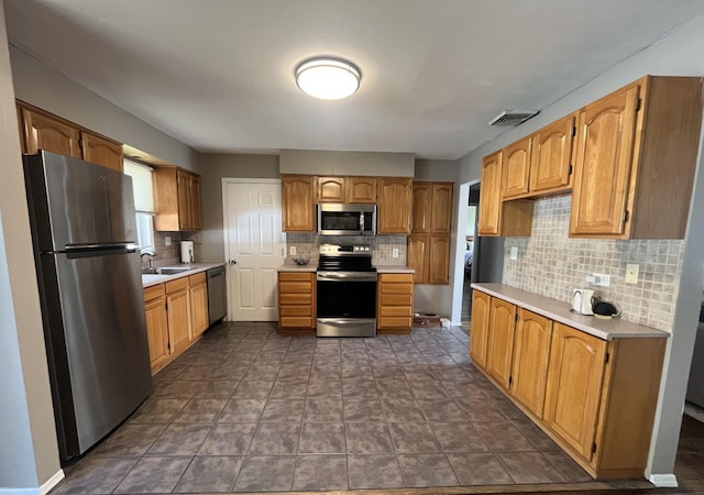kitchen featuring a sink, visible vents, backsplash, light countertops, and appliances with stainless steel finishes