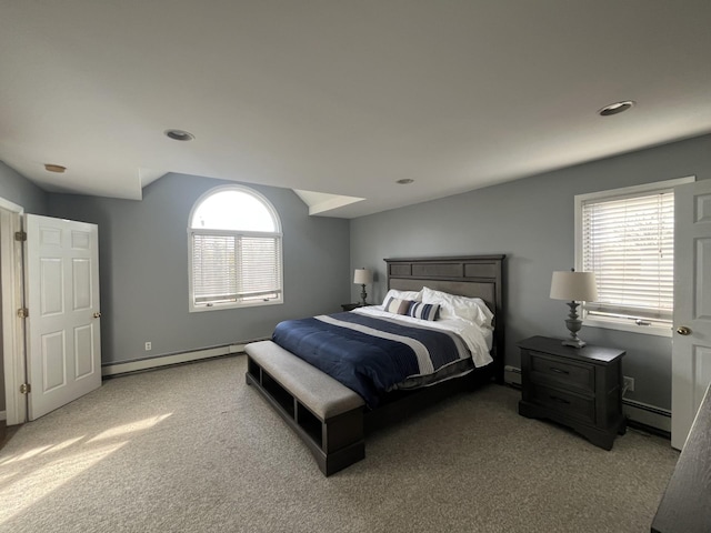 bedroom with baseboard heating, lofted ceiling, and carpet flooring