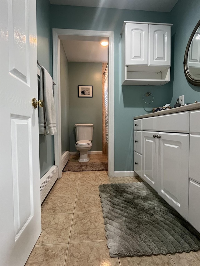 full bath featuring baseboards, vanity, tile patterned flooring, and toilet