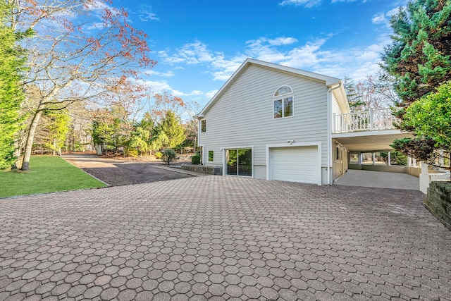 view of side of home featuring an attached garage and decorative driveway