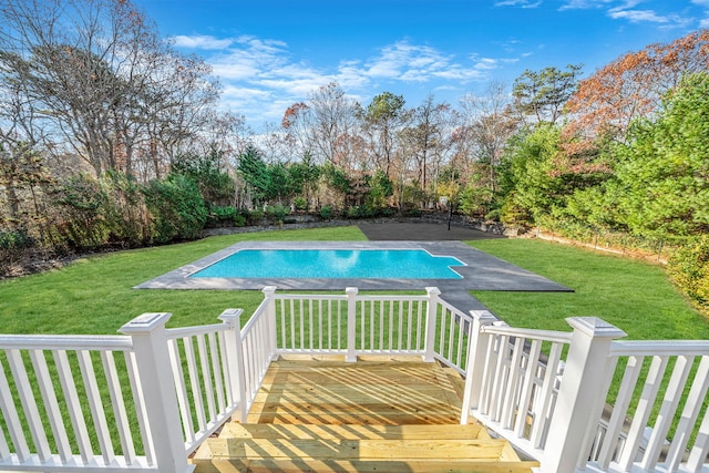 view of swimming pool with a lawn, a deck, and a fenced in pool