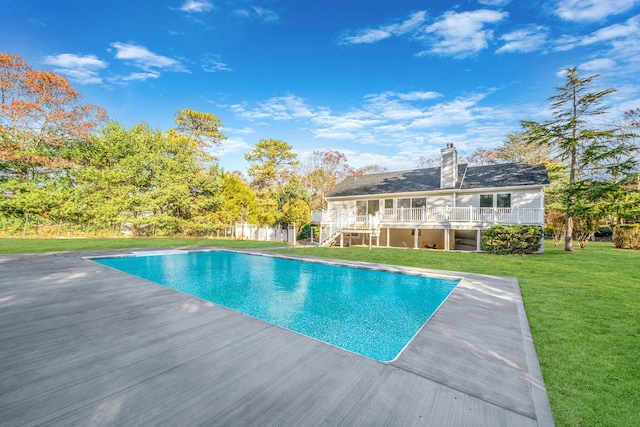 pool featuring a lawn, stairs, and a deck