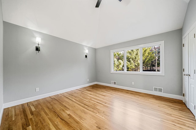unfurnished room with lofted ceiling, visible vents, light wood finished floors, and a ceiling fan