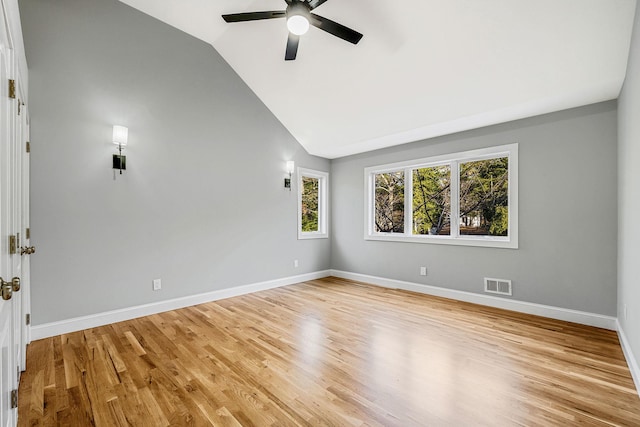 spare room with lofted ceiling, visible vents, light wood finished floors, and ceiling fan