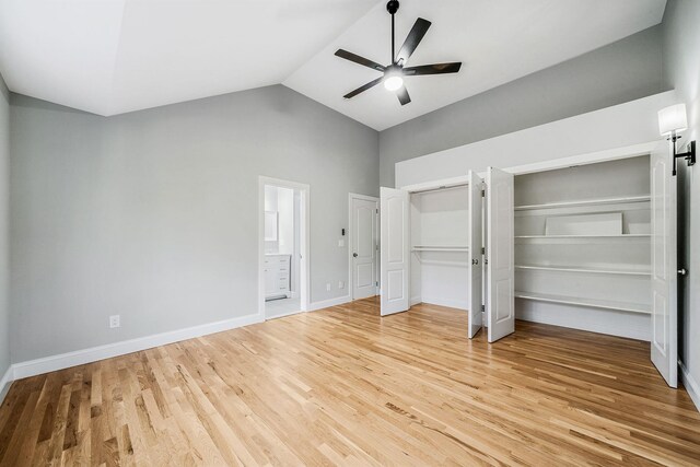 unfurnished bedroom featuring multiple closets, baseboards, light wood-style flooring, high vaulted ceiling, and ceiling fan