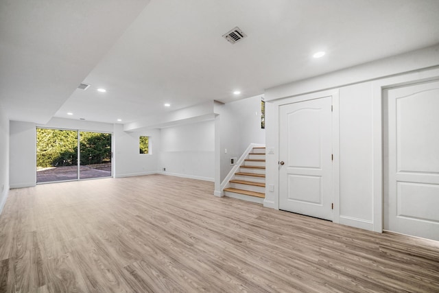 unfurnished living room with recessed lighting, visible vents, light wood finished floors, and stairs