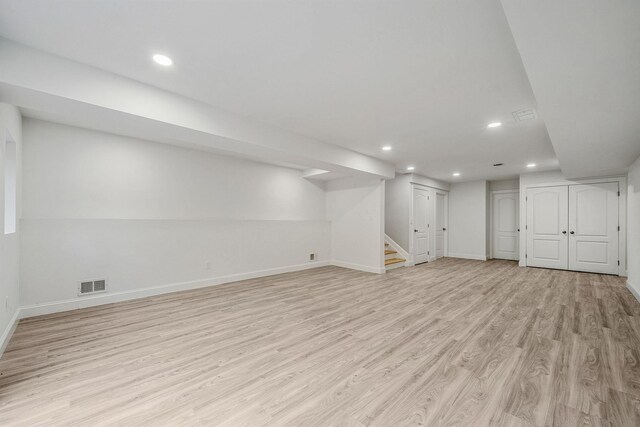 finished basement with light wood finished floors, baseboards, visible vents, and recessed lighting