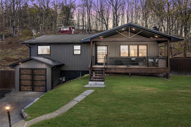 view of front of house with fence, a shingled roof, a front lawn, and aphalt driveway
