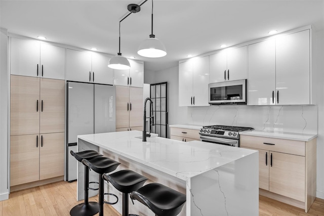 18 Mcbride Pl, Goshen, NY 10924 - kitchen with stainless steel appliances, modern cabinets, light stone countertops, a kitchen bar, and recessed lighting